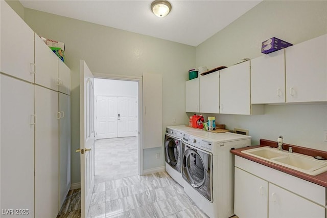 laundry room with cabinets, separate washer and dryer, and sink