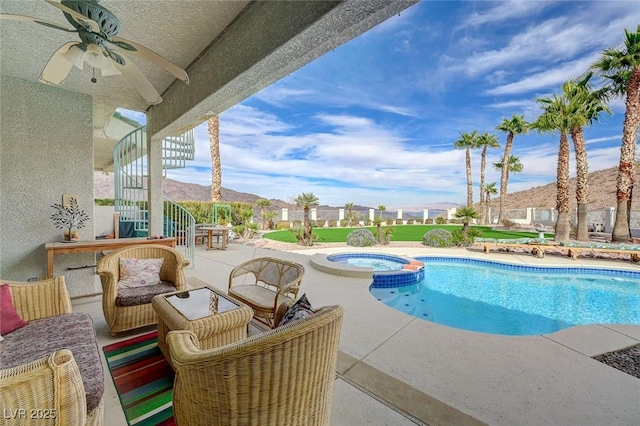 view of pool featuring an in ground hot tub, ceiling fan, a mountain view, and a patio area