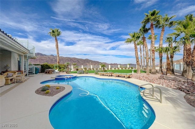 view of swimming pool featuring an in ground hot tub, a mountain view, and a patio area