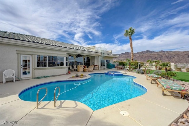 view of swimming pool with an in ground hot tub, a mountain view, and a patio