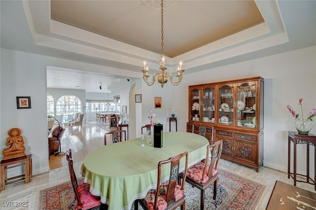 dining room featuring a chandelier and a tray ceiling