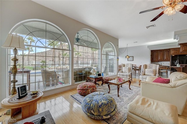 living room with ceiling fan and light hardwood / wood-style floors