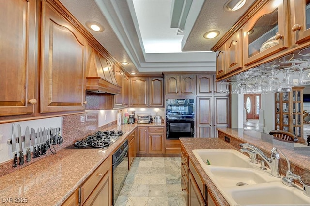 kitchen featuring sink, double oven, decorative backsplash, custom exhaust hood, and stainless steel gas stovetop