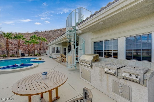 view of swimming pool featuring area for grilling, a patio area, an in ground hot tub, and an outdoor kitchen