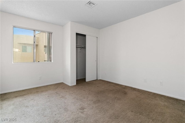 unfurnished bedroom with a closet, carpet flooring, and a textured ceiling