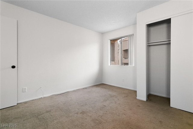 unfurnished bedroom with a closet, a textured ceiling, and carpet flooring