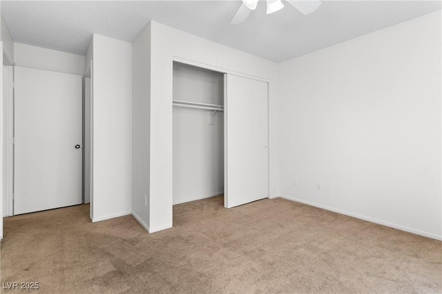 unfurnished bedroom with light colored carpet, a closet, and ceiling fan