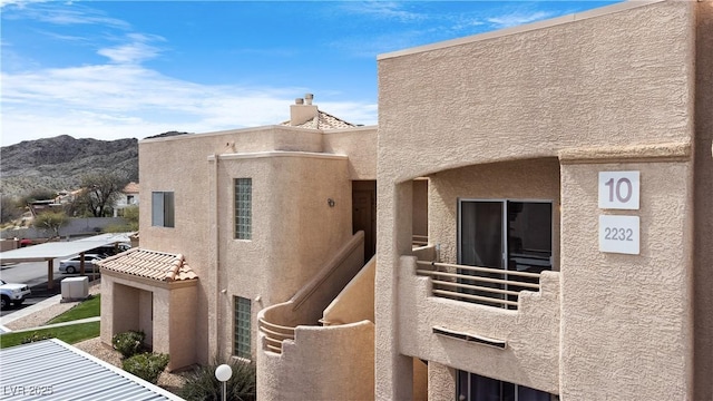 view of side of home with a balcony and a mountain view