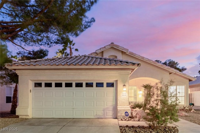 mediterranean / spanish-style house with a garage