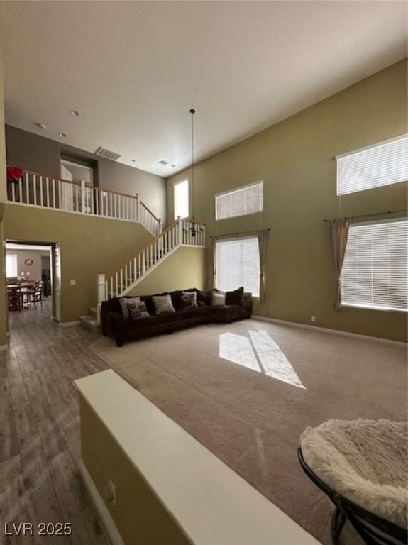 living room featuring a towering ceiling and wood-type flooring