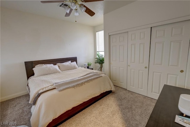 carpeted bedroom featuring ceiling fan and a closet