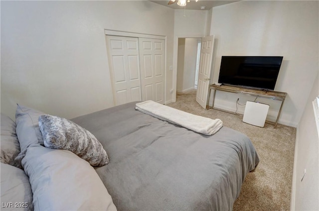 bedroom featuring light carpet, ceiling fan, and a closet