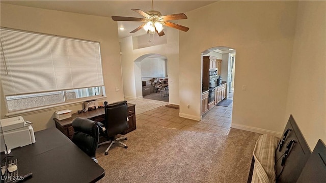 carpeted home office featuring ceiling fan and high vaulted ceiling