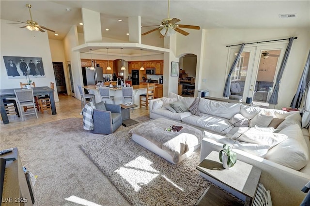 living room with ceiling fan, light tile patterned floors, and high vaulted ceiling