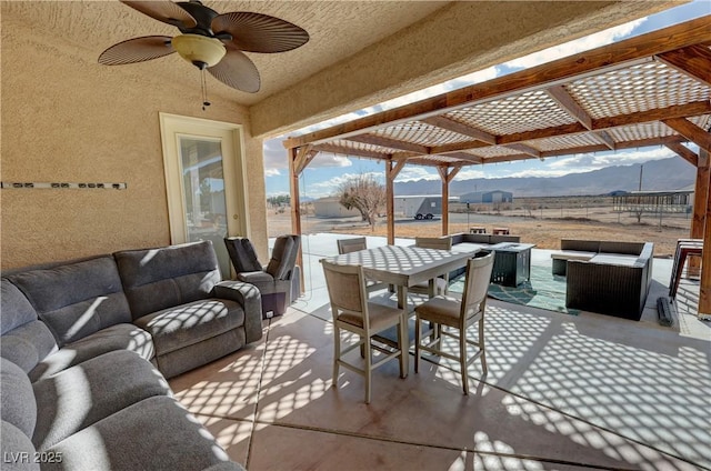 view of patio / terrace with ceiling fan, a pergola, an outdoor hangout area, and a mountain view