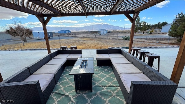 view of patio / terrace with a mountain view, a pergola, and an outdoor living space with a fire pit