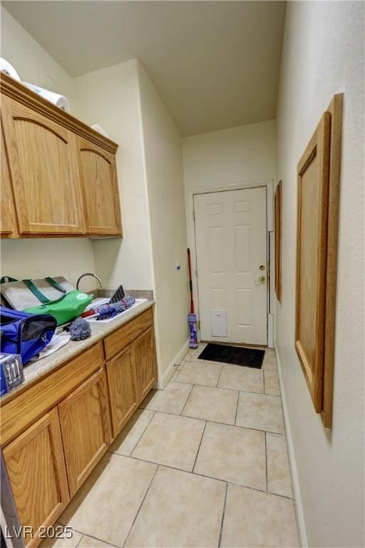 laundry area with light tile patterned floors