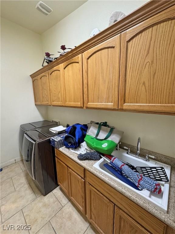 laundry area with cabinets, washing machine and dryer, sink, and light tile patterned floors