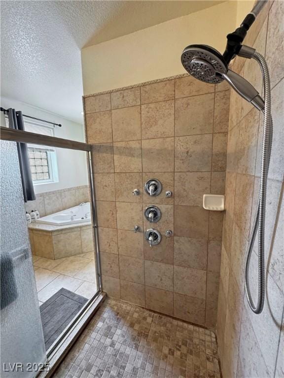 bathroom featuring a textured ceiling and separate shower and tub