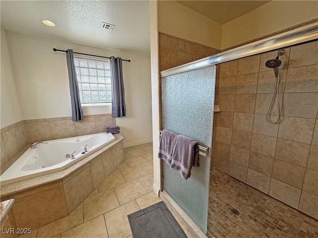 bathroom with independent shower and bath, tile patterned floors, and a textured ceiling