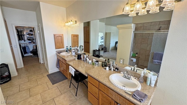 bathroom featuring tile patterned floors, vanity, and a shower with shower door