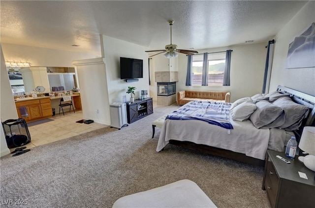 carpeted bedroom featuring ceiling fan and a textured ceiling