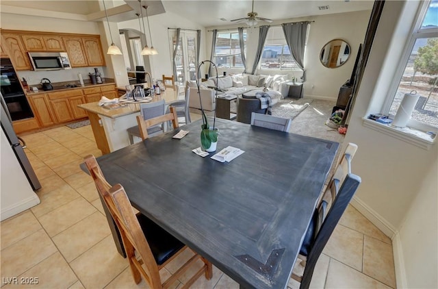 tiled dining area featuring ceiling fan and plenty of natural light