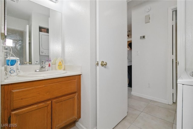 bathroom with vanity, tile patterned floors, and stacked washer and clothes dryer