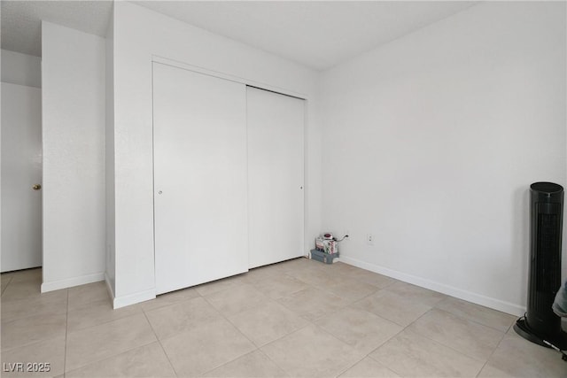 unfurnished bedroom featuring light tile patterned flooring and a closet