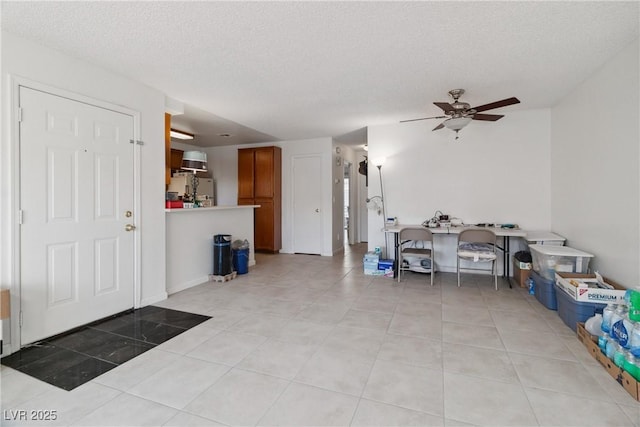 foyer with ceiling fan, light tile patterned floors, and a textured ceiling