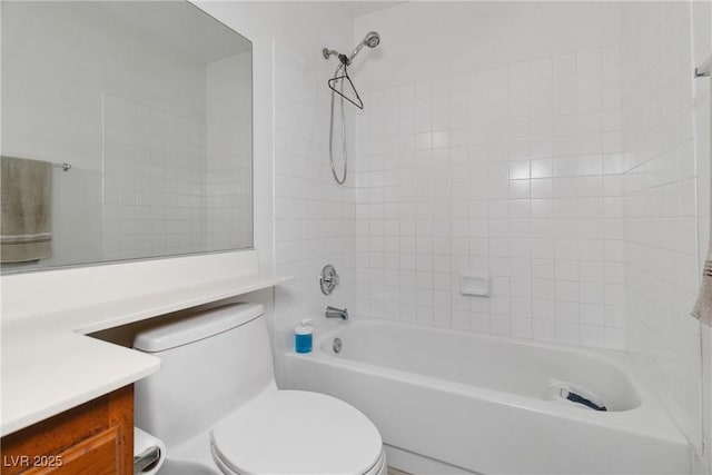 full bathroom featuring vanity, tiled shower / bath combo, and toilet