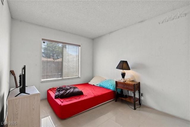 bedroom featuring a textured ceiling and tile patterned floors