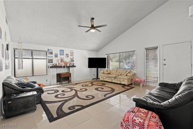 living area with tile patterned flooring, a brick fireplace, a ceiling fan, and a textured ceiling