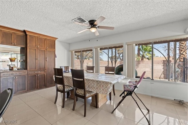 dining room featuring light tile patterned flooring, a ceiling fan, visible vents, and plenty of natural light