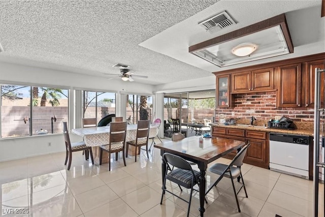 interior space with light tile patterned flooring, visible vents, a raised ceiling, and a wealth of natural light