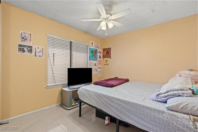 bedroom featuring baseboards, a textured ceiling, and a ceiling fan