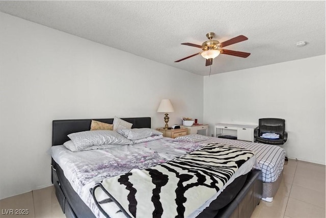 bedroom with light tile patterned floors, a textured ceiling, and a ceiling fan