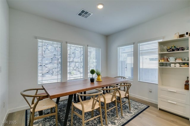 dining area with plenty of natural light and light hardwood / wood-style flooring