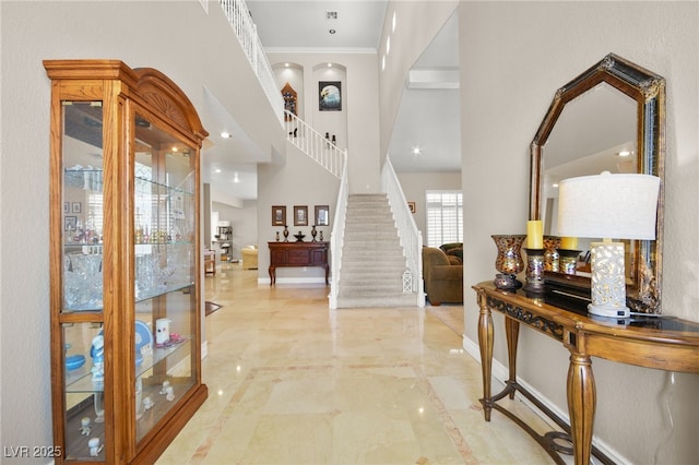 foyer featuring crown molding and a high ceiling