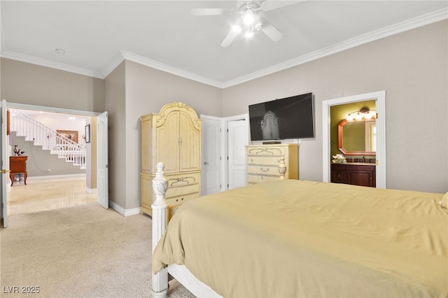 carpeted bedroom featuring ceiling fan, ornamental molding, ensuite bathroom, and sink