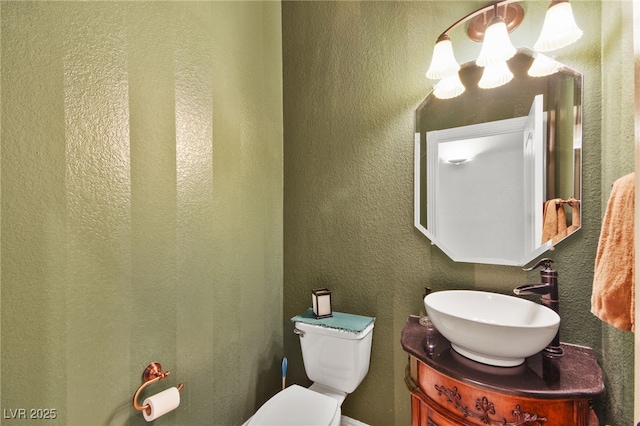 bathroom featuring an inviting chandelier, vanity, and toilet