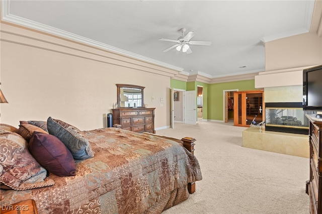 bedroom featuring a fireplace, ornamental molding, ceiling fan, and carpet