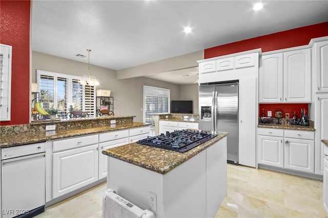 kitchen with white cabinetry, pendant lighting, and dark stone counters