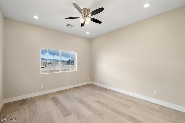 empty room with ceiling fan and light hardwood / wood-style floors