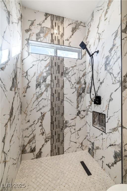 bathroom featuring tiled shower and a wealth of natural light