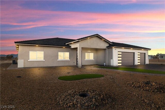 view of front of house featuring a garage and central AC