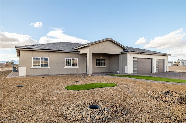 ranch-style house with central AC and a garage