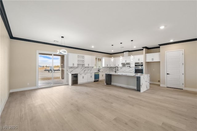 kitchen with white cabinetry, pendant lighting, a center island, and appliances with stainless steel finishes