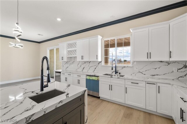 kitchen featuring white cabinetry, sink, stainless steel dishwasher, and decorative light fixtures