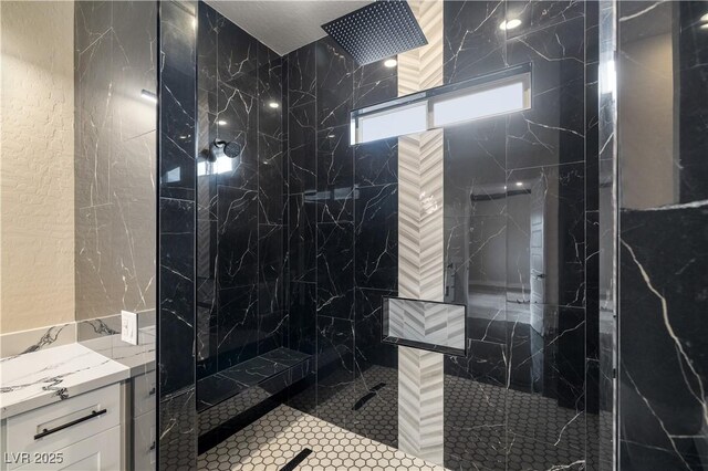 bathroom featuring tiled shower and vanity